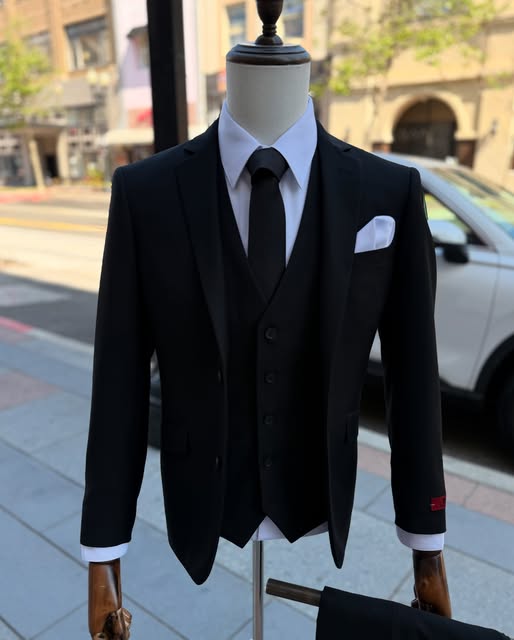A black three-piece suit with a white shirt on a mannequin